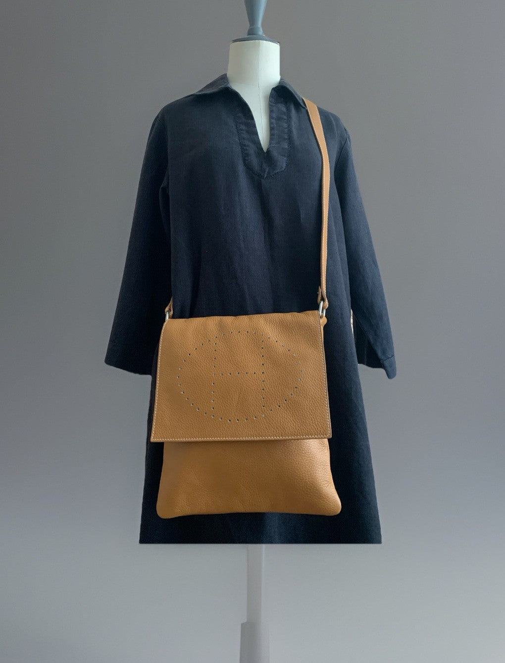 Camelbraune Echtleder-Umhängetasche in der Frontansicht mit Klappe und H Lochmuster