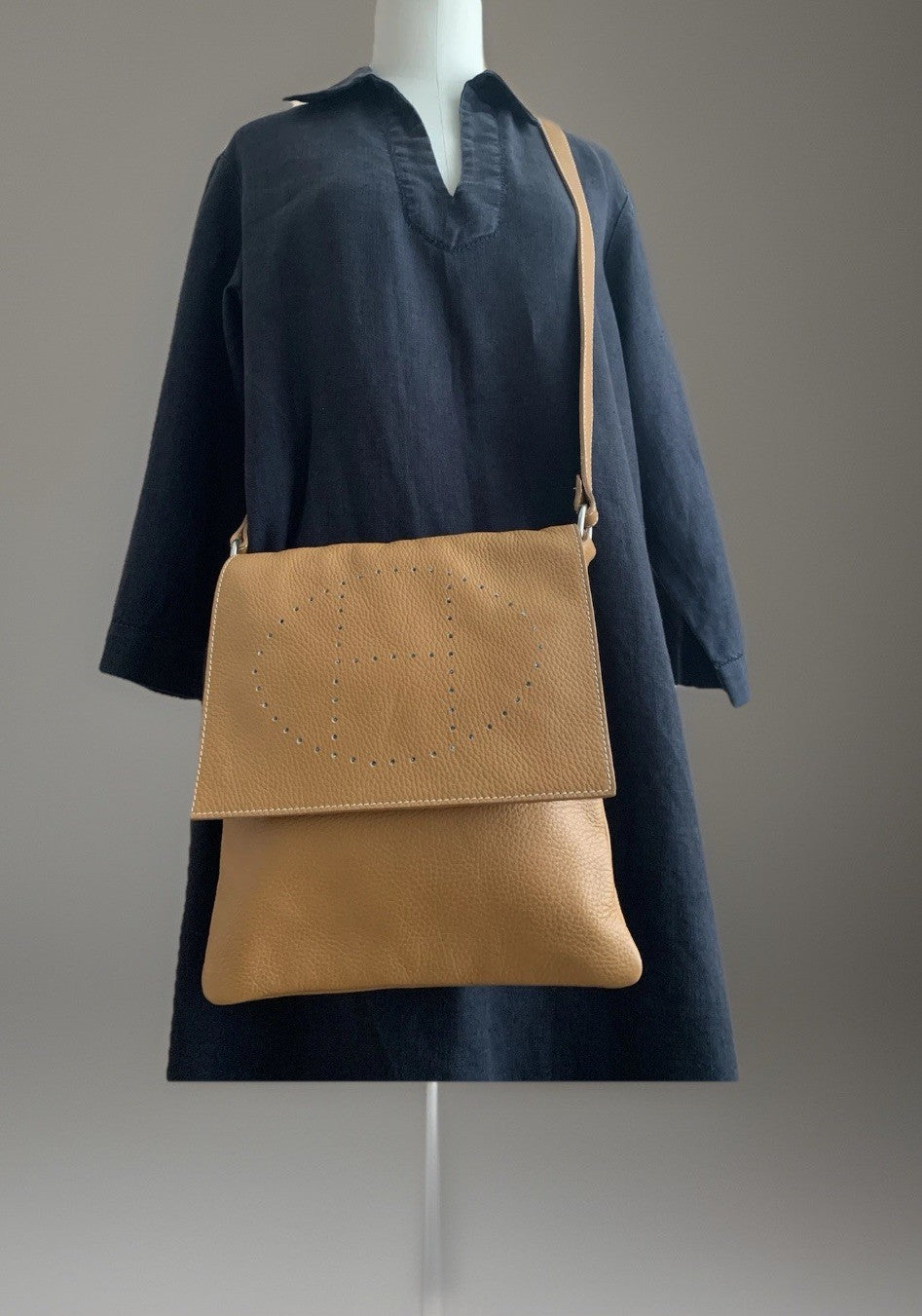 Camelbraune Echtleder-Umhängetasche in der Frontansicht an Puppe