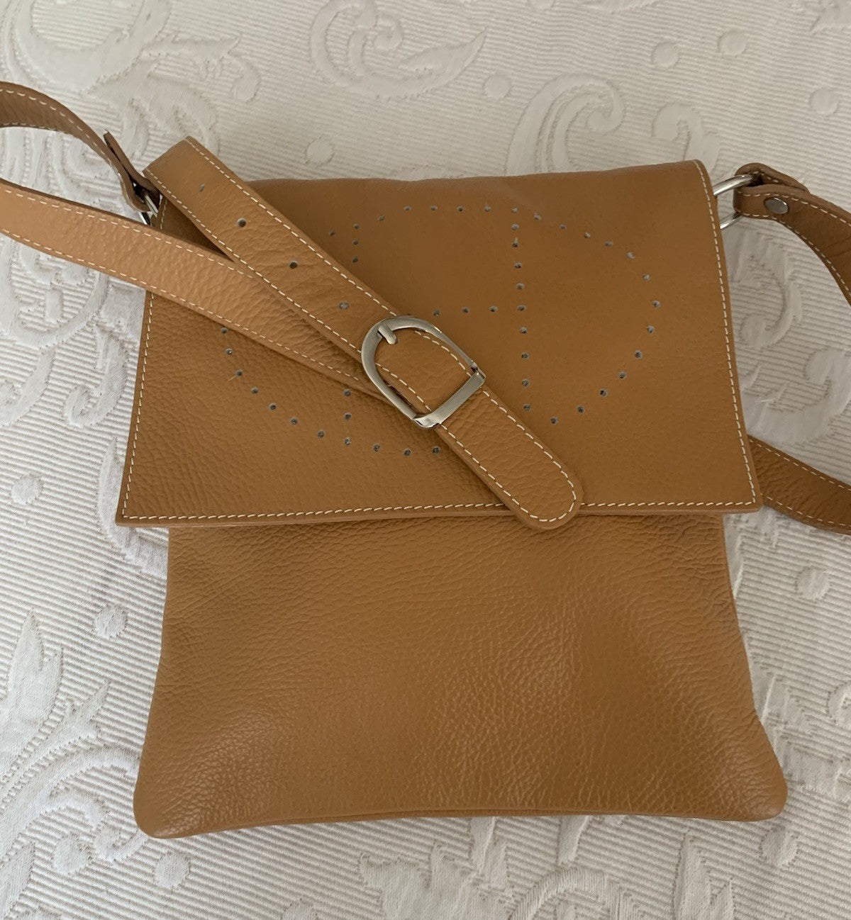 Detailaufnahme des verstellbaren Lederriemens einer camelbraunen Tasche